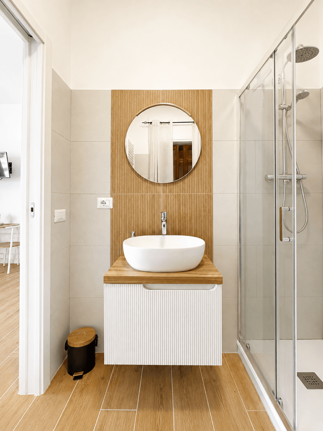 Bagno con specchio rotondo e doccia